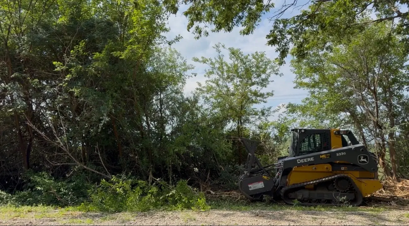 John Deere forestry mulcher beside dense brush